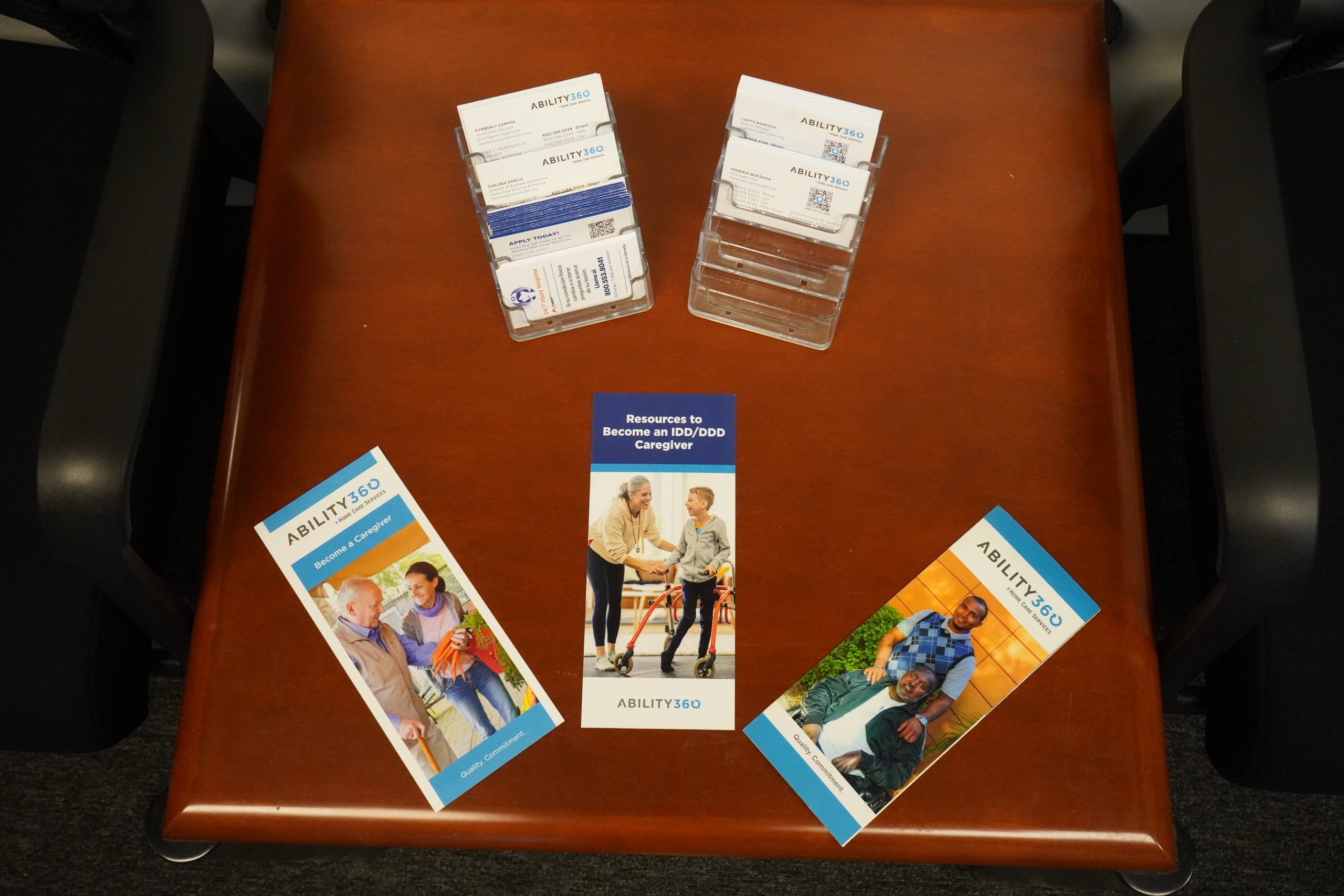 A photo of three ability360 brochures on a brown table