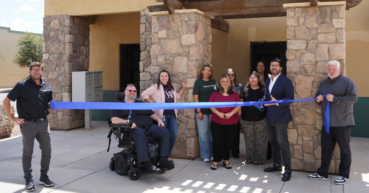 Current image: Ability360 staff prepare to cut a ribbon at the organizations new Casa Grande location.